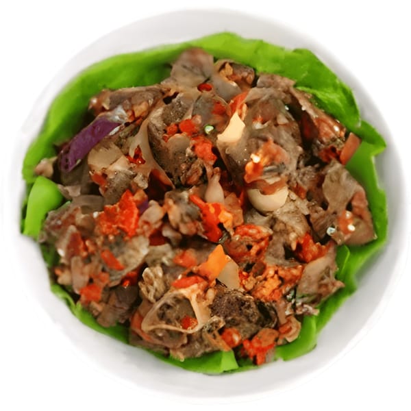 Africaboro's African dish with meat, red peppers, and onions on a bed of green lettuce.